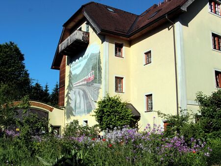 Ostseite Südgartenhaus mit Mariazellerbahnbild und Blüten